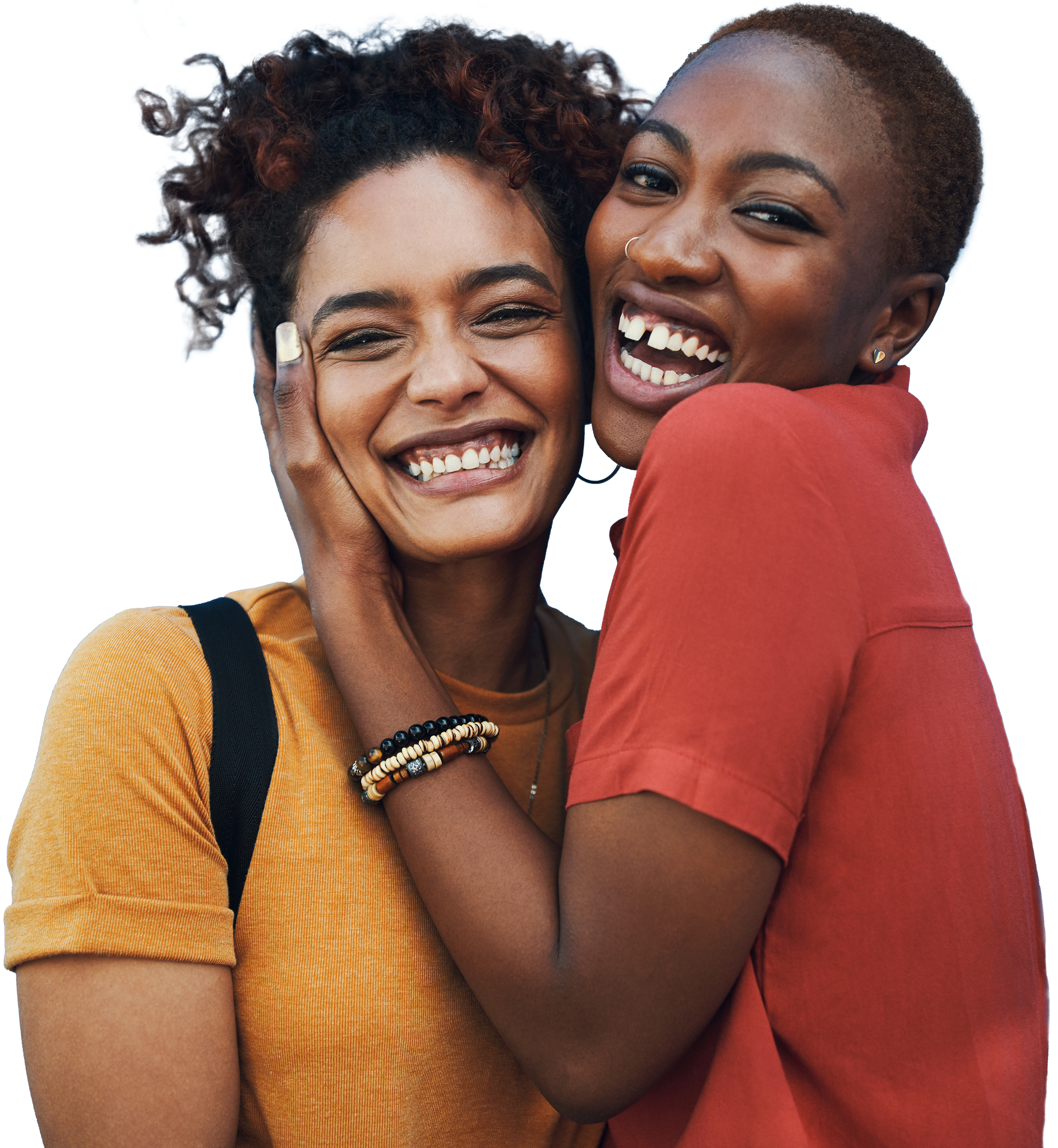 Two friends smile at the camera while they hug